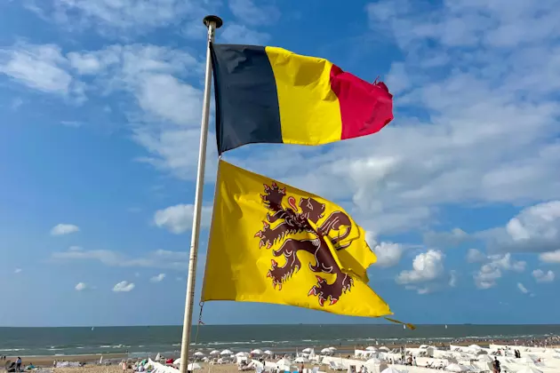 Flaage von Belgien und der Provinz Westflandern am Strand vom Küstenstädtchen De Haan